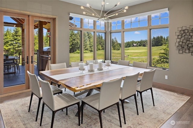 dining area featuring french doors, a chandelier, and light hardwood / wood-style flooring