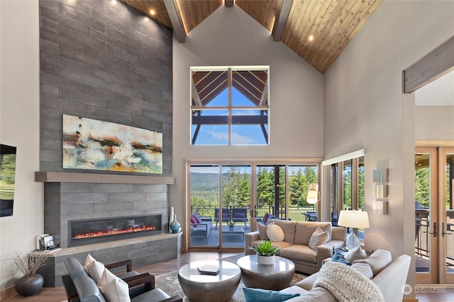 living room featuring high vaulted ceiling, a fireplace, wooden ceiling, and french doors