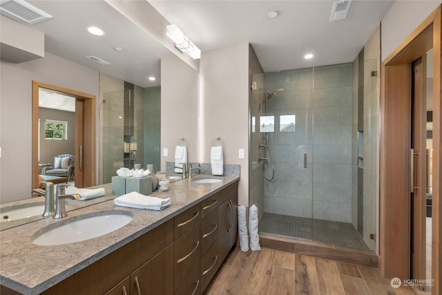 bathroom featuring walk in shower, vanity, and hardwood / wood-style flooring