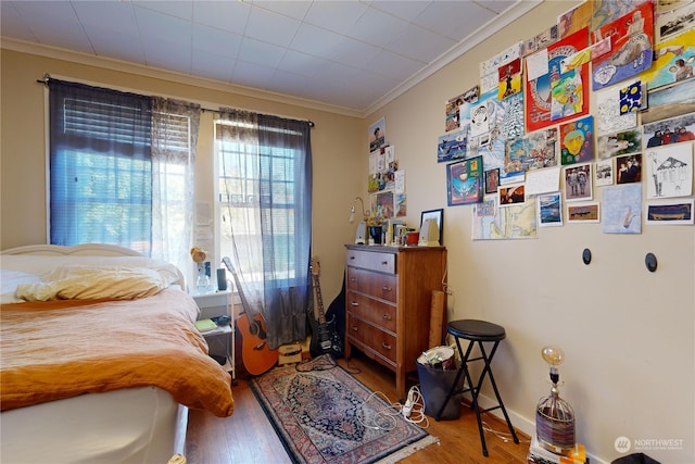 bedroom featuring crown molding and wood finished floors