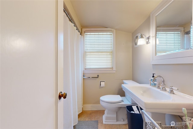 bathroom with lofted ceiling, baseboards, a sink, and toilet