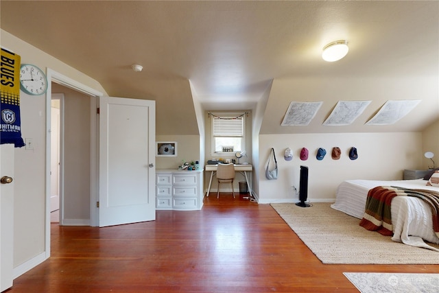 bedroom with lofted ceiling, baseboards, and wood finished floors