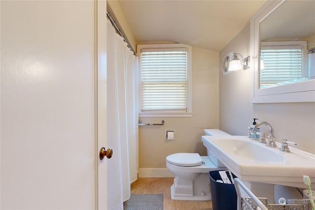 bathroom with toilet, baseboards, a sink, and lofted ceiling