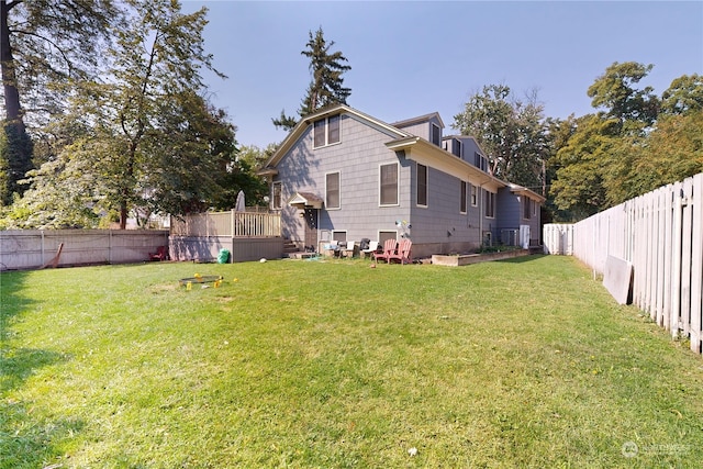 exterior space with a fenced backyard, a yard, and a wooden deck