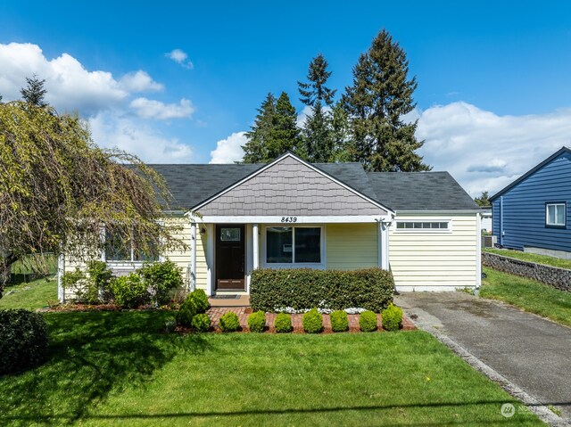 bungalow featuring a garage and a front lawn