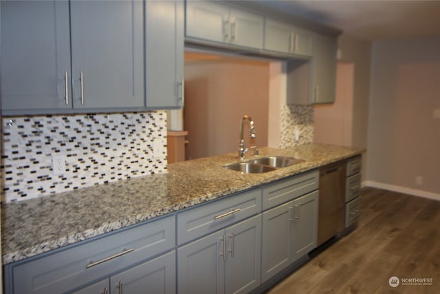 kitchen with light stone counters, dark hardwood / wood-style floors, decorative backsplash, sink, and gray cabinetry