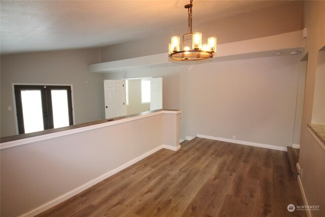 empty room with an inviting chandelier, hardwood / wood-style flooring, and a wealth of natural light