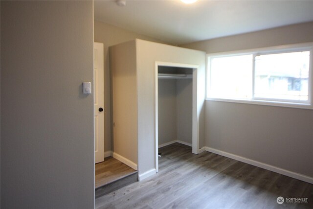 unfurnished bedroom featuring a closet and hardwood / wood-style floors