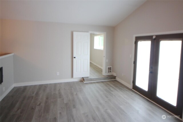 unfurnished living room featuring hardwood / wood-style flooring and vaulted ceiling