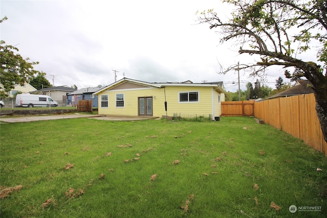 rear view of house featuring a yard and a patio