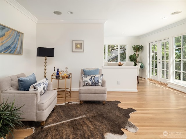 living room with ornamental molding, french doors, and light hardwood / wood-style floors