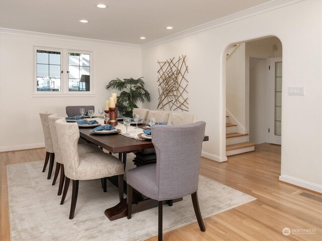 dining space featuring light hardwood / wood-style flooring and crown molding