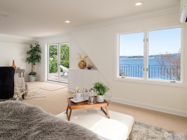 sitting room with a wall mounted AC, a water view, carpet floors, and ornamental molding