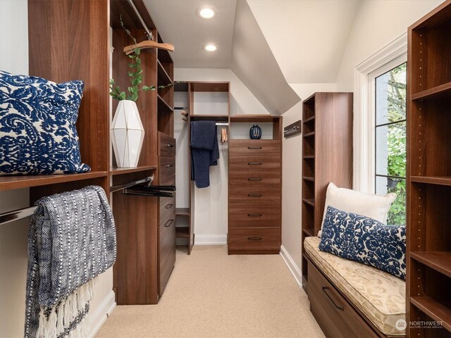 spacious closet featuring vaulted ceiling and light colored carpet