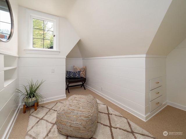 living area featuring light carpet and vaulted ceiling