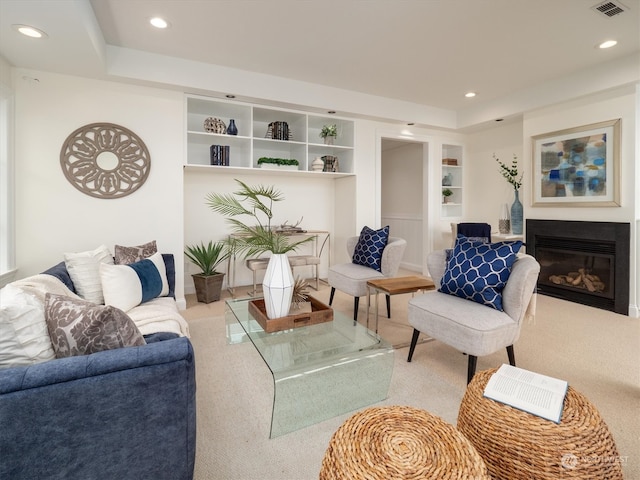 carpeted living room featuring built in features and a tray ceiling