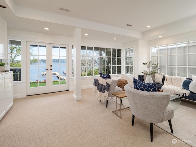 interior space with a water view, french doors, and a wealth of natural light