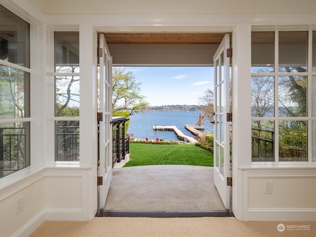 doorway with a water view and carpet floors