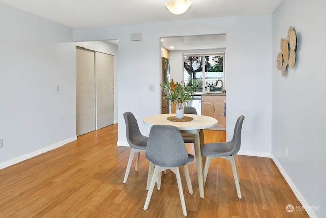 dining space featuring sink and light hardwood / wood-style floors