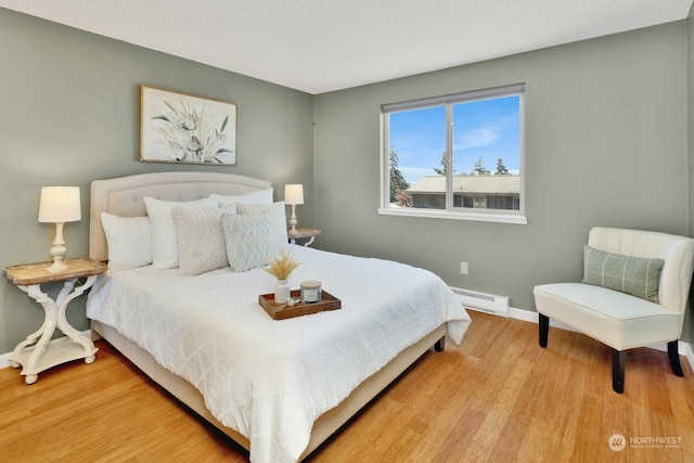 bedroom featuring light hardwood / wood-style flooring and baseboard heating