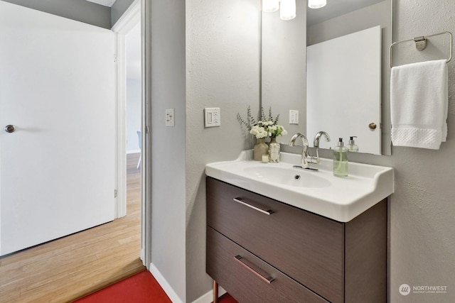 bathroom with hardwood / wood-style flooring and vanity