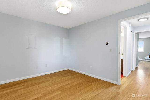 unfurnished room featuring a textured ceiling and light wood-type flooring