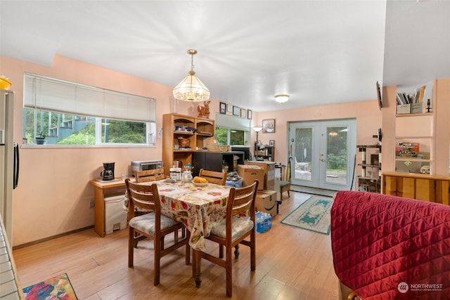 dining space featuring french doors and light wood-type flooring