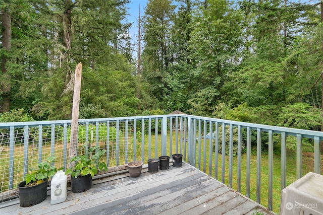 wooden deck featuring a lawn