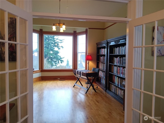 home office with hardwood / wood-style floors and an inviting chandelier