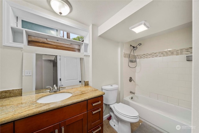 full bathroom featuring tiled shower / bath, vanity, and toilet