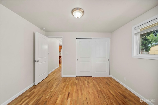 unfurnished bedroom featuring light hardwood / wood-style flooring and a closet