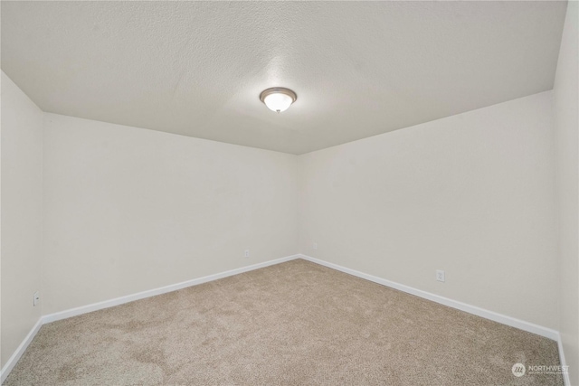 empty room with carpet and a textured ceiling