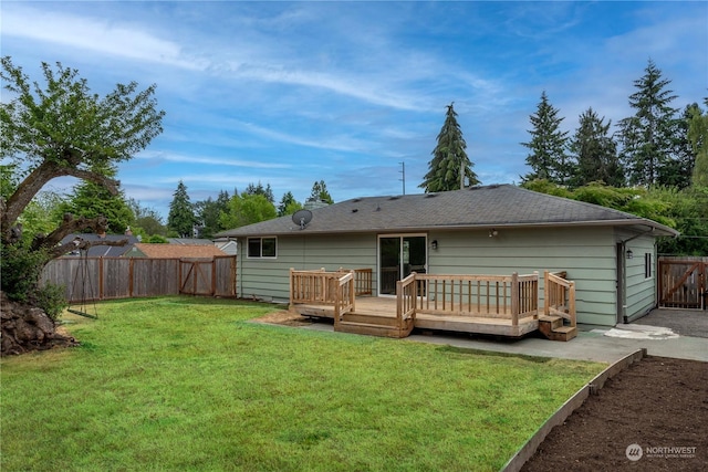 rear view of house with a yard and a deck