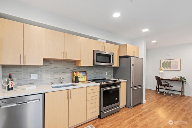 kitchen featuring light brown cabinetry, sink, light hardwood / wood-style flooring, and stainless steel appliances