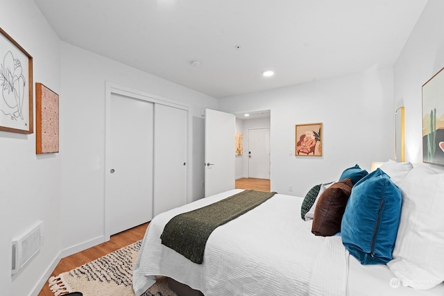 bedroom with light hardwood / wood-style floors and a closet