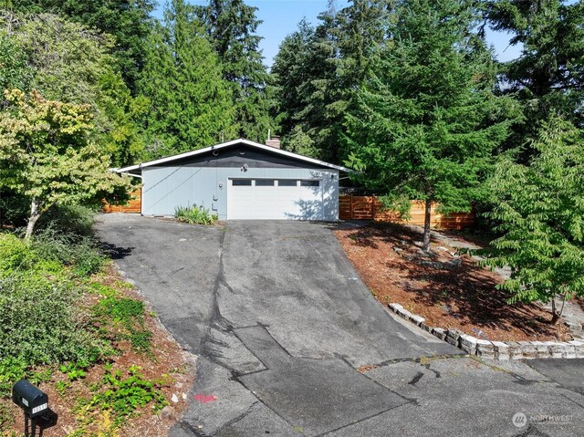 view of front of house featuring a garage and an outbuilding