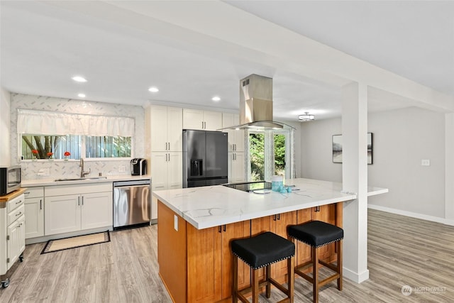 kitchen with white cabinets, island exhaust hood, sink, and black appliances