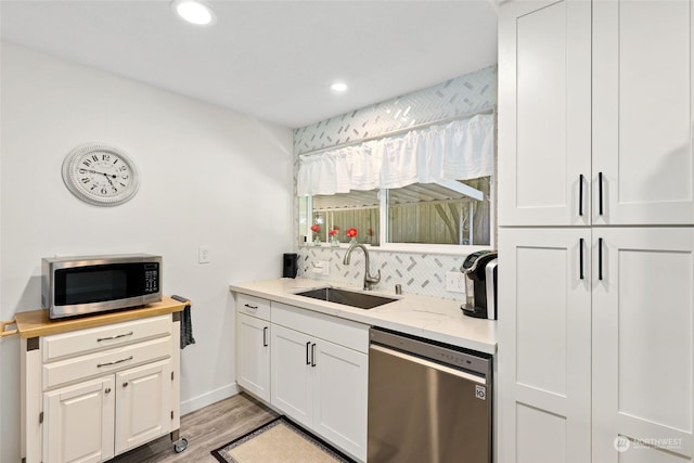 kitchen with white cabinetry, sink, stainless steel appliances, and light hardwood / wood-style floors