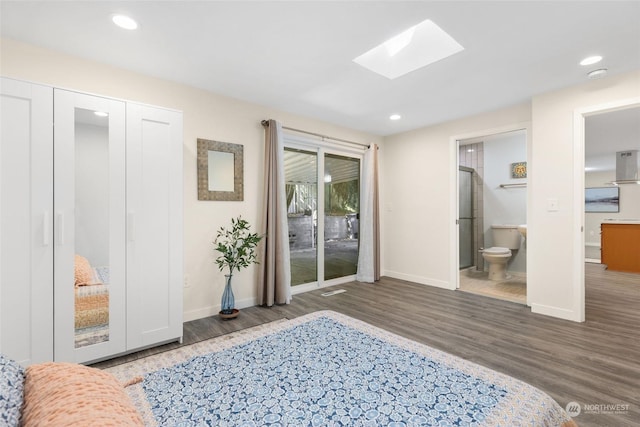 bedroom featuring ensuite bath, dark hardwood / wood-style floors, a skylight, and access to outside