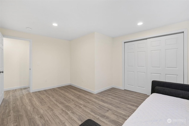 bedroom with light hardwood / wood-style floors and a closet