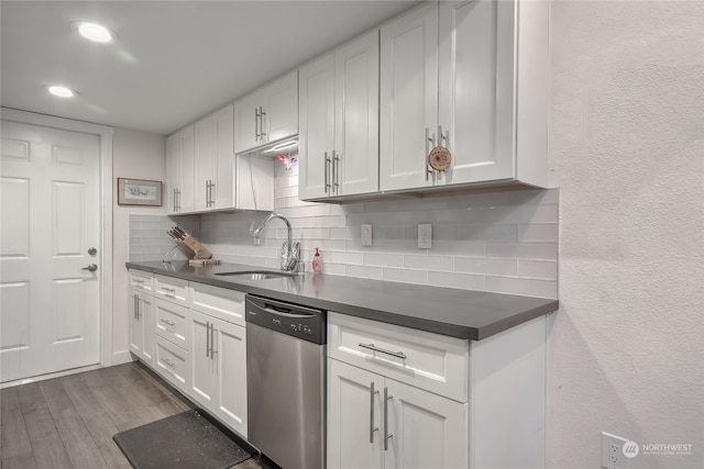 kitchen featuring hardwood / wood-style floors, white cabinetry, stainless steel dishwasher, and sink