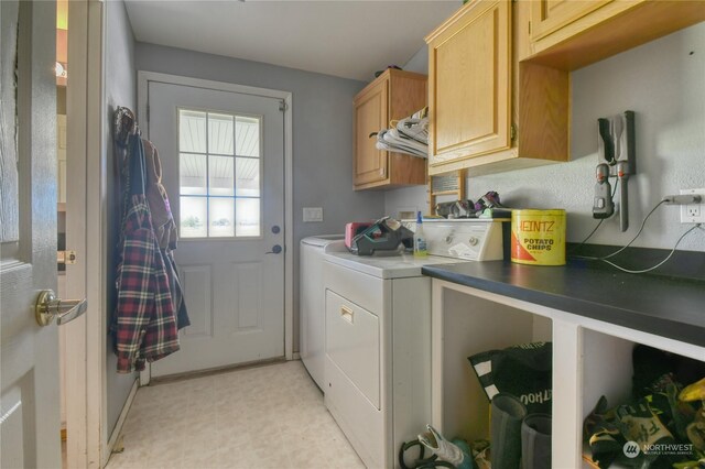 clothes washing area with washer and dryer and cabinets