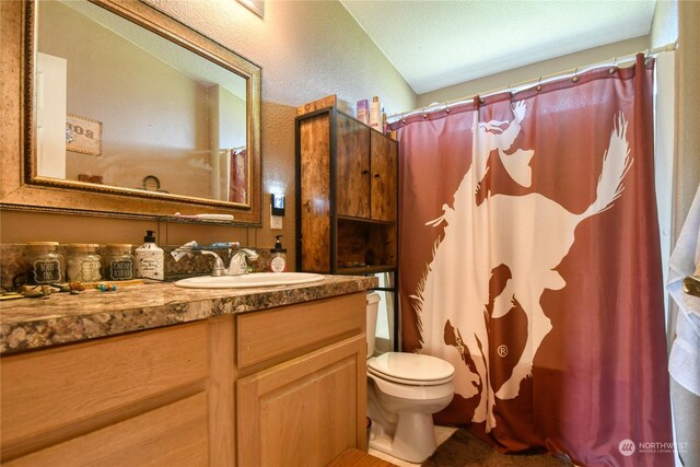 bathroom with walk in shower, vanity, and toilet