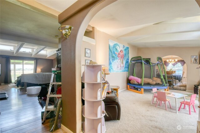 rec room with lofted ceiling and a notable chandelier