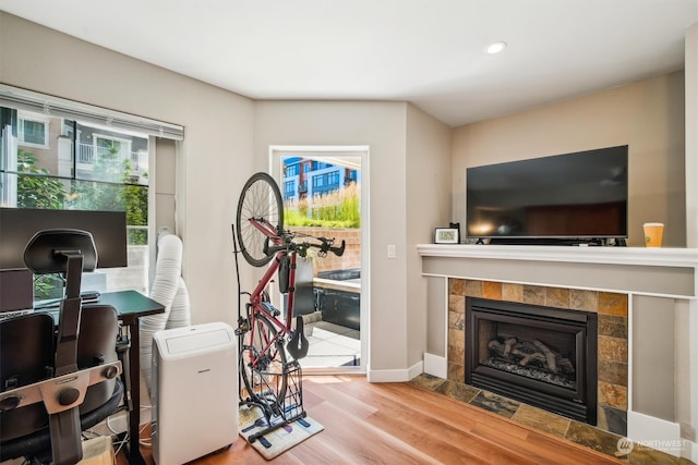 office space with wood-type flooring and a tile fireplace