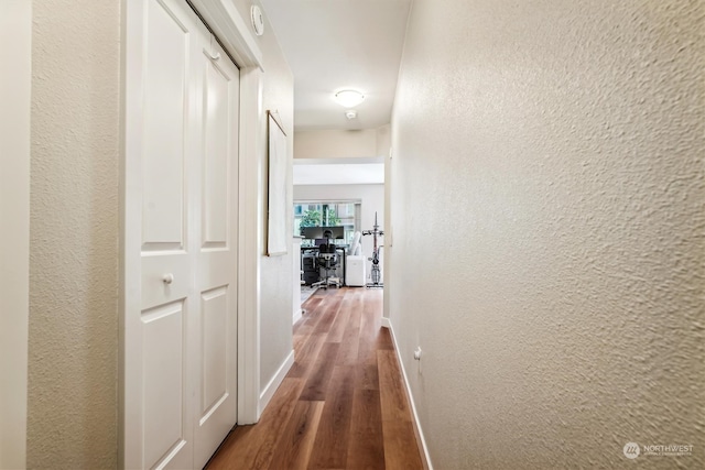 corridor with hardwood / wood-style flooring