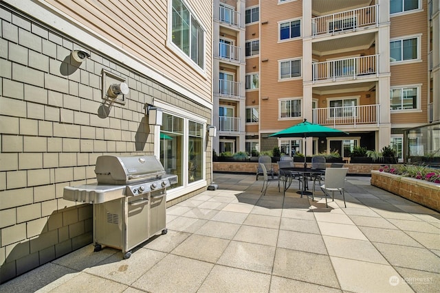 view of patio with a balcony and a grill