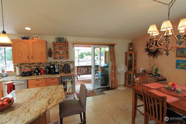 kitchen with light stone counters, hanging light fixtures, stainless steel dishwasher, and open shelves