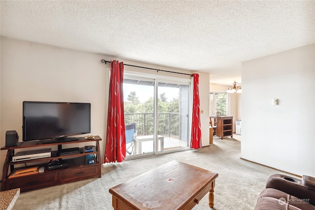 living room featuring light carpet, a notable chandelier, and a textured ceiling