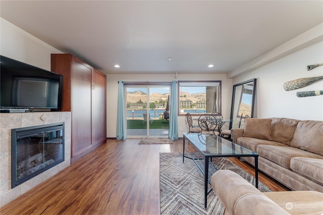 living room featuring hardwood / wood-style flooring and a tile fireplace